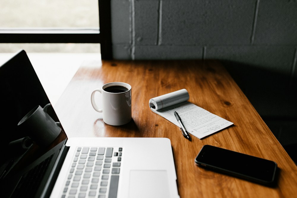 Editorial workspace with a laptop, notebook, and writing materials for content planning