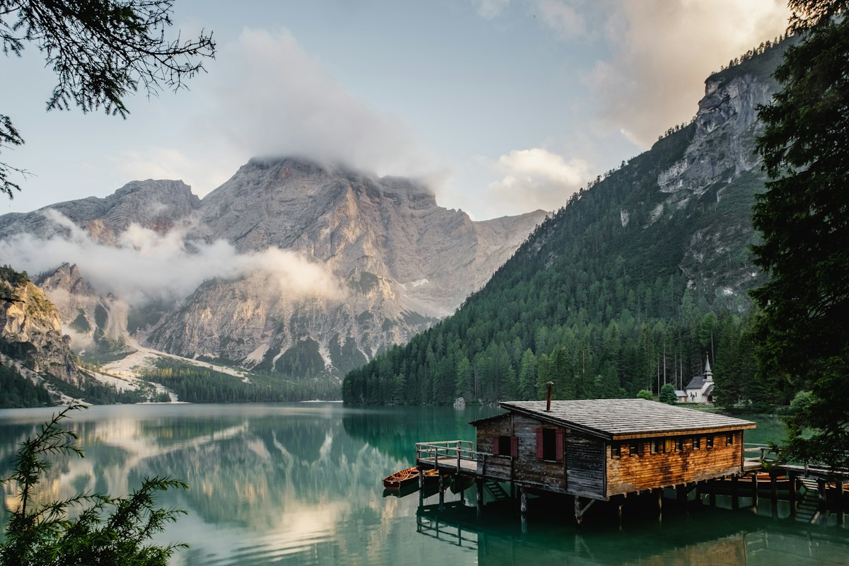 Wide alpine landscape reflected in a calm lake, suggesting a clear long-term perspective